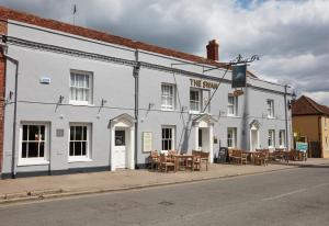 een wit gebouw met tafels en stoelen ervoor bij Swan Hotel by Greene King Inns in Thaxted