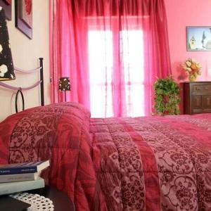 - une chambre avec un lit doté d'une couverture rouge et d'une fenêtre dans l'établissement Vesuvio Bed & Breakfast, à Scafati