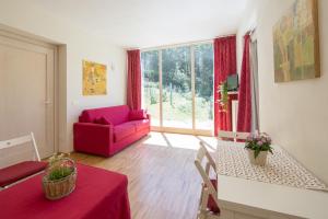 a living room with a red couch and a table at Agriturismo Rossolampone in San Bernardino Verbano