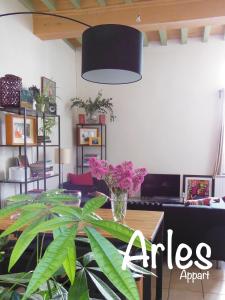 una habitación con una mesa con un jarrón de flores en Appartement Arles Centre Historique, en Arles