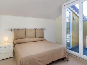 a white bedroom with a bed and a window at Libra Flexyrent in Rapallo