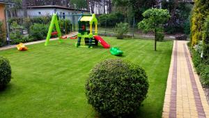a park with a playground with a green lawn at Alkado Domki Jurata in Jurata