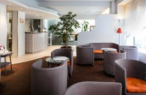 una hall con sedie e tavolo e un angolo bar con servizio di vendita di asterisco. di Best Western Astoria a Juan-les-Pins