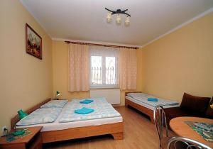 a bedroom with two beds and a couch at Penzión Centrál in Oščadnica
