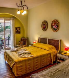 a bedroom with a bed with a yellow bedspread at Hotel Mato in Skiathos Town