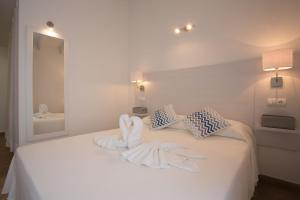 a bedroom with a bed with towels on it at Hotel Rosamar - Emar Hotels in Es Pujols