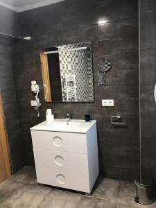 uma casa de banho com um lavatório branco e um espelho. em Villalodosa em Lodosa