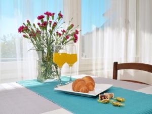 uma mesa com um prato de croissants e copos de sumo de laranja em Studio apartment Andela em Marina