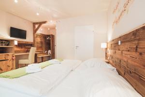 a bedroom with two white beds and a desk at Weinwirtshaus Wlaschits in Klingenbach +26 photos