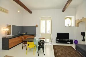 ein Wohnzimmer mit einem Glastisch und gelben Stühlen in der Unterkunft IzzHome Light in Cagliari