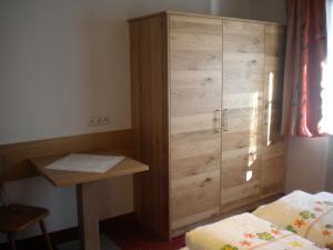 a bedroom with a large wooden cabinet next to a bed at Erika Sporer in Hippach +11 photos