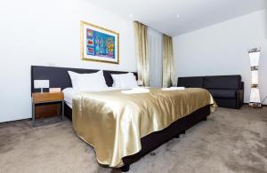 a bedroom with a large bed with a gold blanket at Hotel Marul in Split