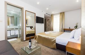 Habitación de hotel con cama y sofá en Hotel Marul, en Split