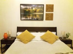 a bedroom with a bed with yellow pillows at Near To Pisa Airport Guesthouse in Pisa