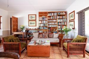 a living room with a couch and bookshelves at AmaSun B&B in George