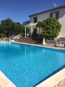 a large blue swimming pool in front of a building at B&B LA MARCHESA in SantʼAnastasia