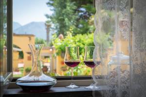 three glasses of wine sitting on a window sill at Hotel Villa Rita in Paestum