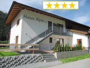 ein Gebäude mit einem Schild, auf dem das Haus alpin steht in der Unterkunft Haus Alpin Apartments in Pettneu am Arlberg