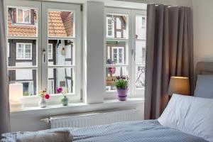 1 dormitorio con 3 ventanas y 1 cama con colcha en Wertschätzer I - Karlstr en Detmold