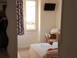 a small room with a bed and a window at Villa TerraMera Hôtel in Le Lavandou