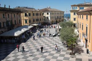 a group of people walking down a city street at IN PIAZZA appartamento con vista in Lazise