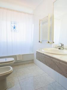 a white bathroom with a sink and a toilet at Hotel Stellamaris in Combarro