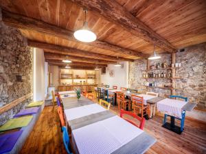 a dining room with tables and chairs and a stone wall at Locanda del Silenzio Hotel in Macra