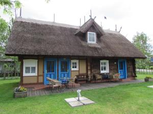 a log cabin with a thatched roof and a patio at Ferienwohnung Zum Heuschober in Burg