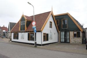 un bâtiment blanc avec un toit marron dans une rue dans l'établissement Hotel West Inn, à Hippolytushoef