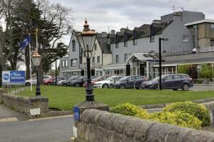 uma luz de rua ao lado de uma rua com carros estacionados em Best Western Kings Manor em Edimburgo