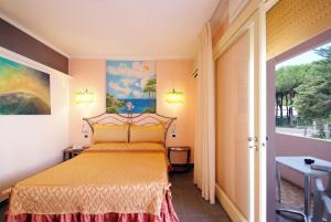 1 dormitorio con 1 cama con colcha amarilla en Hotel Barcarola 2, en Marina di Campo