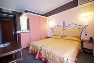 a bedroom with a large bed and a table at Hotel Barcarola 2 in Marina di Campo