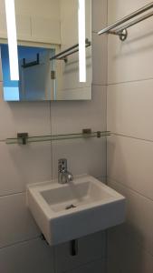a bathroom with a white sink and a mirror at Canal Garden Apartment StayWell Amsterdam in Amsterdam +43 photos