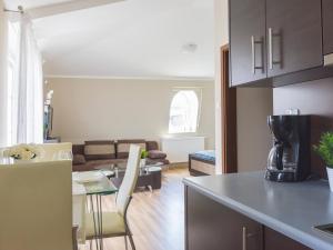 a kitchen and a living room with a table at VacationClub - Regina Maris Apartment 71 in Świnoujście