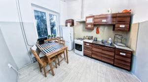 a kitchen with wooden cabinets and a table in it at Place4Us in Warsaw