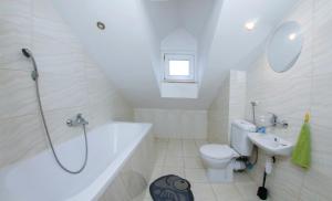 uma casa de banho com uma banheira, um WC e um lavatório. em Place4Us em Varsóvia