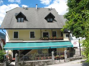 a house with two windows and a balcony with flowers at APARTMAJI STARI KOVAČ in Bovec