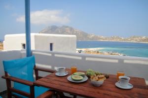 een tafel met eten op een balkon met uitzicht op de oceaan bij Aspes Village in Aiyiáli