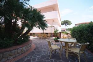 eine Terrasse mit Stühlen und einem Tisch in einem Gebäude in der Unterkunft Hotel Barcarola 2 in Marina di Campo