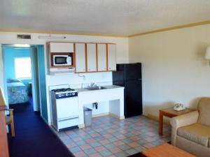 a small kitchen with a stove and a sink at Cerca Del Mar Motel in Virginia Beach