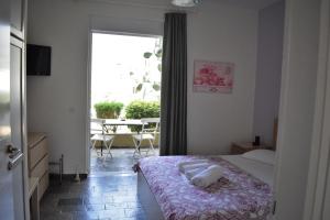 a bedroom with a bed and a window with a table at To Livadi in Lefkogeia