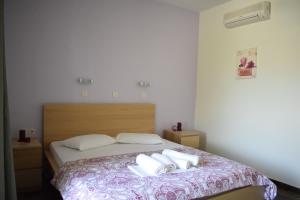 a bedroom with a bed with two towels on it at To Livadi in Lefkogeia