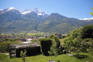 a village in a valley with mountains in the background at Beauregard apartment in Aosta