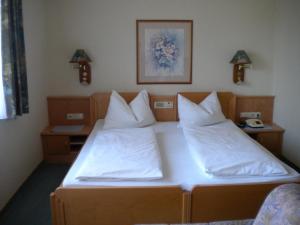 a bedroom with two beds with white sheets at Pension Köberl in Bad Mitterndorf