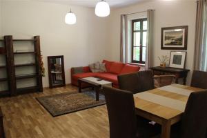 ナウェンチュフにあるWilla Widok - Apartament Naleczowのリビングルーム(赤いソファ、テーブル付)