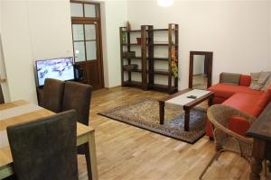 un soggiorno con divano rosso e tavolo di Willa Widok - Apartament Naleczow a Nałęczów