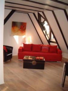 salon z czerwoną kanapą i stołem w obiekcie Appartement Kirschgarten Mainz Rochusstraße w Moguncji