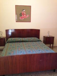 カスタニェート・カルドゥッチにあるAzienda Agricola Paradisoのベッドルーム1室(木製ベッド1台、ナイトスタンド2台付)