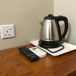 a tea kettle and a remote control on a counter at Se One Hotel in Butterworth