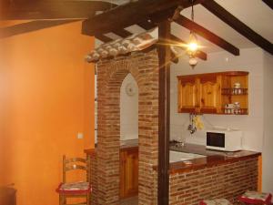 a kitchen with a brick fireplace and a microwave at Viviendas Rurales Traldega in Turieno